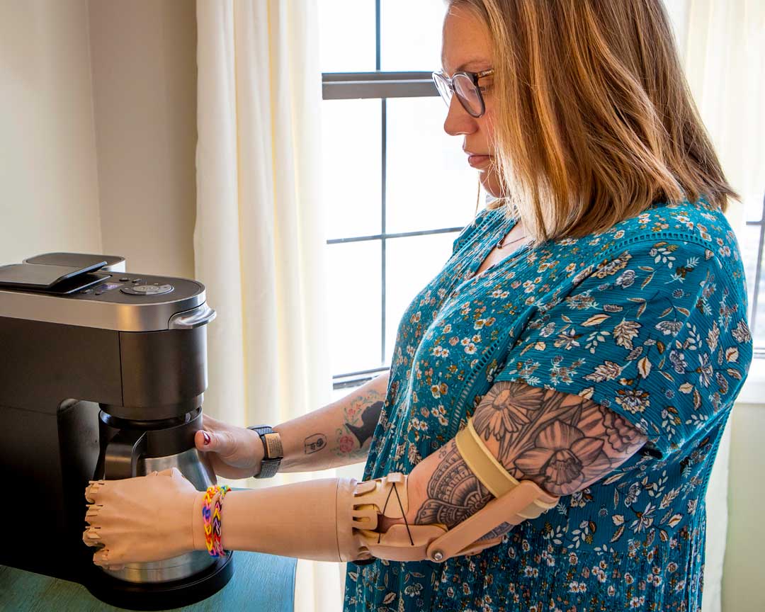 A woman with tattoos controlling a bionic arm